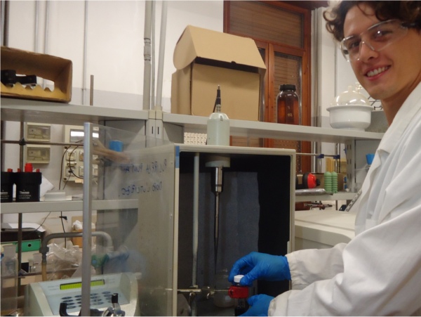 a young chemist working with a sonicator and smiling