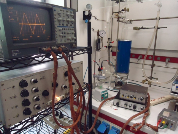 oscilloscope connected to an electrochemical apparatus in a fume hood
